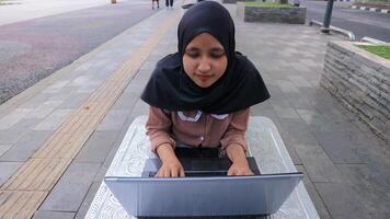 retrato do árabe o negócio mulheres trabalhando em computador portátil sentado às cidade parque. foto