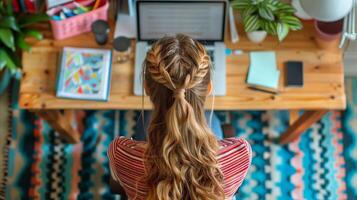 mulher trabalhando a partir de casa em computador portátil com trançado cabelo foto