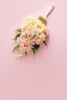 escova tintas com flores, Primavera conceito em pastel Rosa fundo. mínimo natureza plano deitar. uma cópia de espaço. vertical visualizar. foto