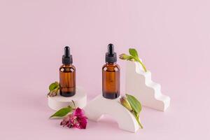 dois Cosmético garrafas com uma conta-gotas com uma natural orgânico produtos em pé em geométrico pódios com brotos do astromeria . embalagem, produtos brincar. foto