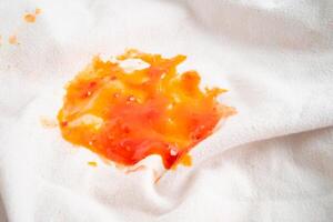 sujo tomate molho mancha ou ketchup em pano para lavar com lavando pó, limpeza tarefas domésticas. foto