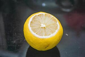 uma amarelo limão isolado em Sombrio vidro foto