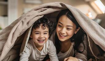 mãe e criança estão jogando debaixo uma cobertor foto