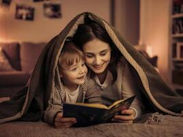 mãe e criança estão lendo livro debaixo uma cobertor foto