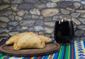 norte empanadas, carne fritas e uma vidro do vermelho vinho. Argentino gastronomia foto