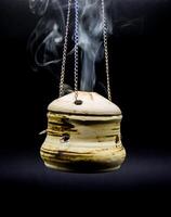 tigela do incenso suspensão fumaça em Preto fundo foto