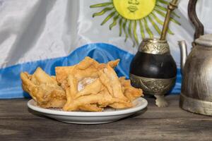 erva amigo, guitarra e frito pastelaria, símbolos do a Argentino tradição foto