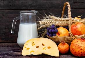 jarro com leite, queijo trigo e frutas shavuot conceito foto