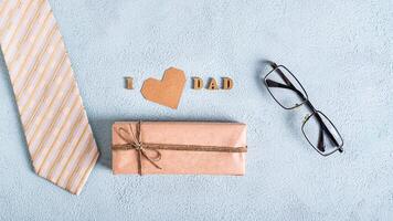 do pai dia construir presente, cartão coração, gravata, óculos e inscrição em uma azul fundo foto