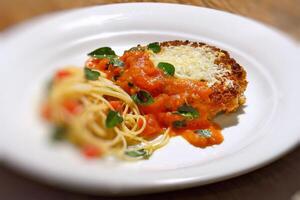 filé al parmigiano com espaguete com picado tomates foto