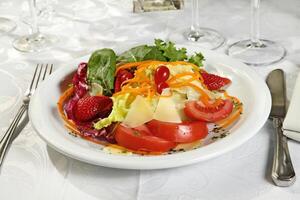 tropical salada com alface, tomates, queijo, cenouras e morangos foto