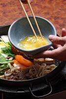 passo a passo guia para Sukiyaki, uma clássico japonês prato com vegetais, manteiga, molho, carne e tofu queijo foto