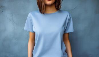 jovem mulher vestindo em branco azul camiseta dentro frente do a cinzento muro. brincar camiseta modelo. foto