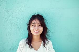 jovem sorridente ásia mulher dentro frente do a azul parede foto