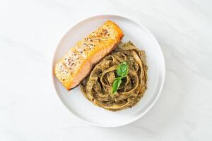 macarrão espaguete pesto fettuccine com filé de salmão grelhado foto