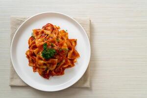 macarrão farfalle em molho de tomate com salsa foto