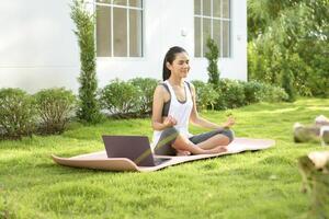 jovem mulher dentro roupa de esporte fazendo meditação prática e ioga ar livre, saudável estilo de vida, mental saúde conceito. foto