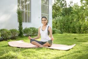 jovem mulher dentro roupa de esporte fazendo meditação prática e ioga ar livre, saudável estilo de vida, mental saúde conceito. foto