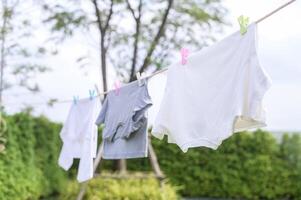 roupas suspensão lavanderia em lavando linha para secagem contra azul céu ao ar livre foto