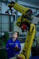 fêmea robótica engenheiro trabalhando com programação e manipulando robô mão, industrial robótica projeto, Alto tecnologia instalação, moderno máquina aprendizado. massa Produção automáticos. foto