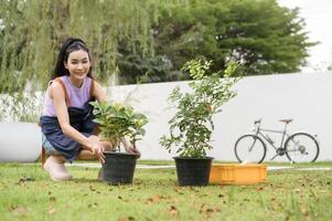 jovem ásia mulher plantio árvore dentro a jardim ao ar livre às lar. foto