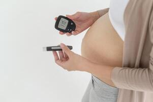 grávida mulher verificação sangue açúcar nível de usando digital glicose metro, saúde Cuidado, medicamento, diabetes, glicemia conceito foto