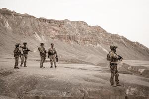 soldados dentro camuflar uniformes visando com seus rifles prontos para fogo durante militares Operação dentro a deserto soldados Treinamento dentro uma militares Operação foto