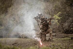 soldados dentro camuflar uniformes visando com seus rifles prontos para fogo durante militares Operação dentro a floresta soldados Treinamento dentro uma militares Operação foto