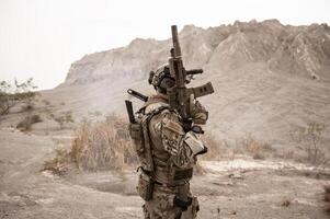 soldados dentro camuflar uniformes visando com seus rifles prontos para fogo durante militares Operação dentro a deserto soldados Treinamento dentro uma militares Operação foto