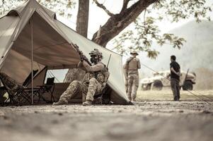 soldados dentro camuflar uniformes planejamento em Operação dentro a acampamento, soldados Treinamento dentro uma militares Operação foto