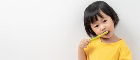 pequeno ásia menina usar escova de dente para limpar, sofre a partir de dor dentro dente. dentes decair, dental problemas, dente escovar prática, oral saúde Cuidado, reduzindo doces, flúor Revestimento foto