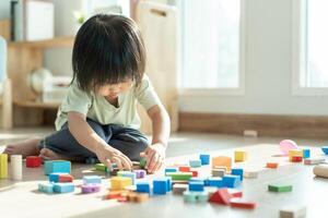 feliz ásia criança jogando e Aprendendo brinquedo blocos. crianças estão muito feliz e animado às lar. criança ter uma ótimo Tempo jogando, Atividades, desenvolvimento, atenção déficit hiperatividade transtorno foto