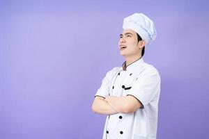 jovem ásia masculino chefe de cozinha em fundo foto