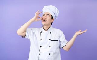 jovem ásia masculino chefe de cozinha em fundo foto