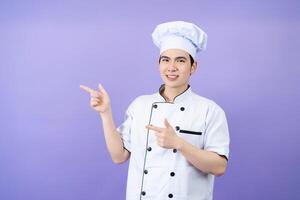 jovem ásia masculino chefe de cozinha em fundo foto