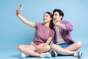 jovem ásia casal em azul fundo foto