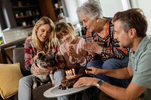 feliz família a comemorar avós aniversário com bolo dentro uma acolhedor vivo quarto foto