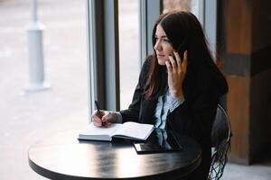 empresária falando em a telefone e levando notas foto