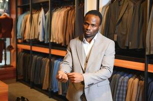jovem africano homem compras dentro roupas loja foto