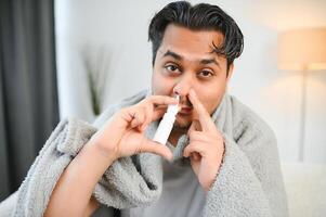 uma doente indiano é tratado às casa e usa uma nasal spray. cuidados de saúde conceito foto