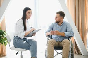 retrato do fêmea psiquiatra entrevistando deficiente homem durante terapia sessão, cópia de espaço. foto