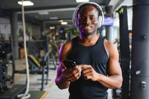 jovem afro-americano homem dentro uma Academia preparando para exercício foto