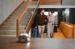 casal em uma o negócio viagem fazendo check-in às a hotel foto