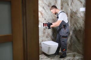 encanador instalando banheiro dentro Sanitário foto