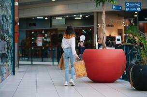 compras tempo, Adolescência menina com compras bolsas às compras shopping center. compras conceito foto