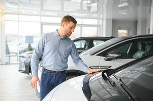 conceito do comprando elétrico veículo. bonito o negócio homem carrinhos perto elétrico carro às concessionária foto