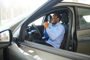 alegre Preto homem sentado dentro luxo automóvel, teste dirigir, transporte foto