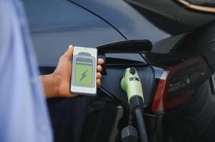 africano americano homem cobrando dele elétrico carro. foto