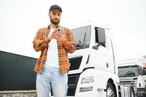 retrato do jovem barbudo homem em pé de dele caminhão. profissional caminhão motorista em pé de semi caminhão veículo. foto