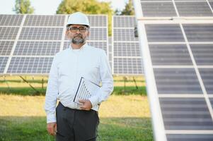 Senior engenheiro trabalhando em solar painel Fazenda. a conceito do verde energia foto